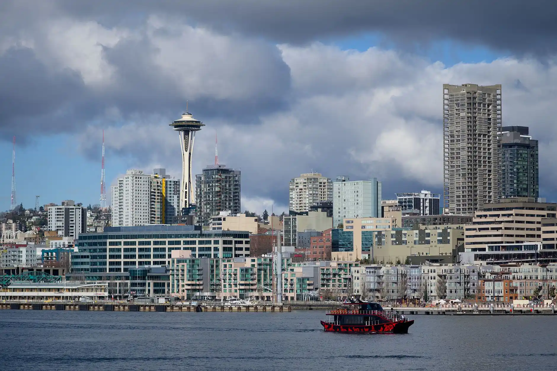 Side-by-side lineup of a Cadillac Escalade, premium black SUV, executive sedan, and classic black town car against the Seattle skyline